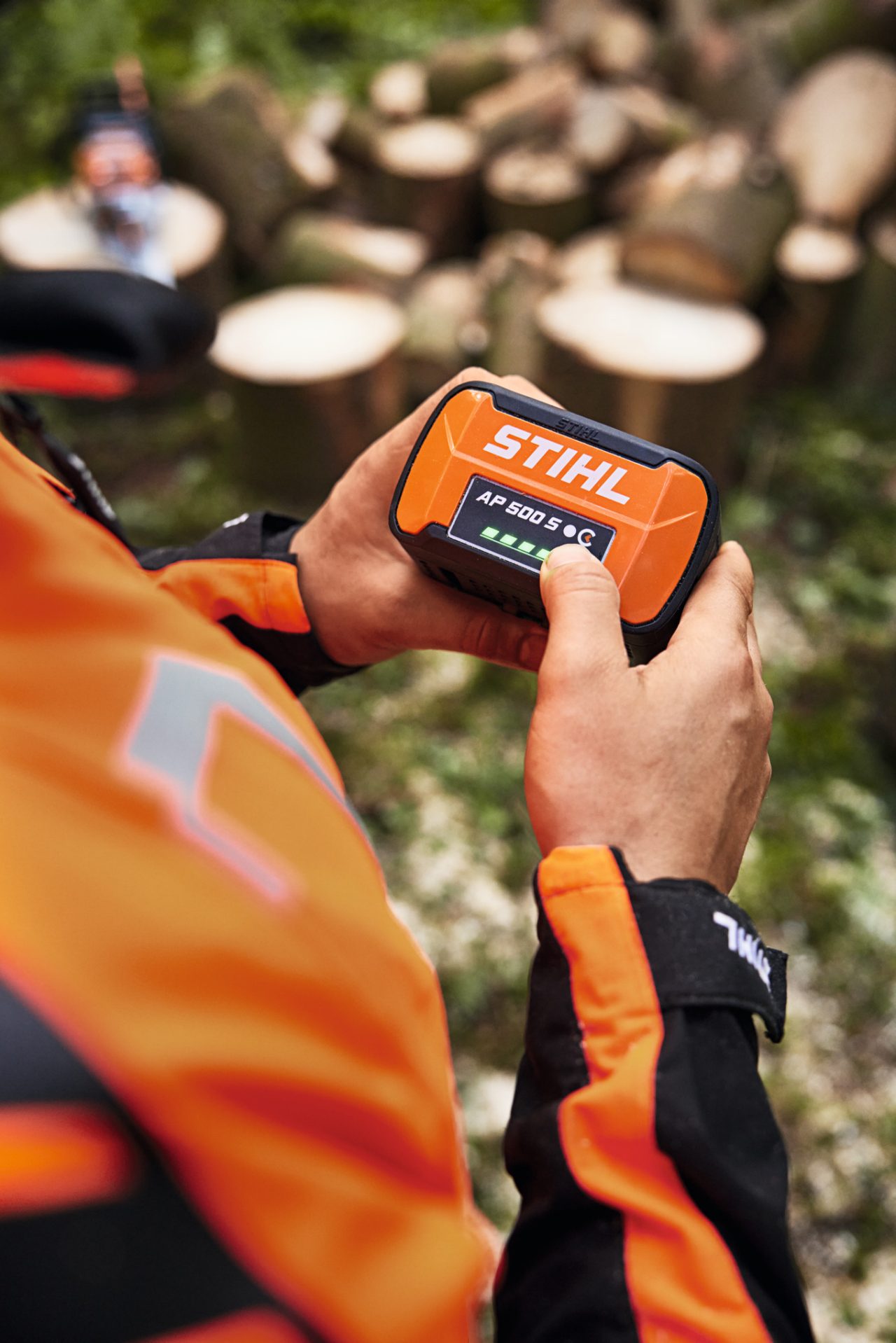 Grande plano de uma pessoa com a bateria de iões de lítio STIHL AP 500 S nas mãos.