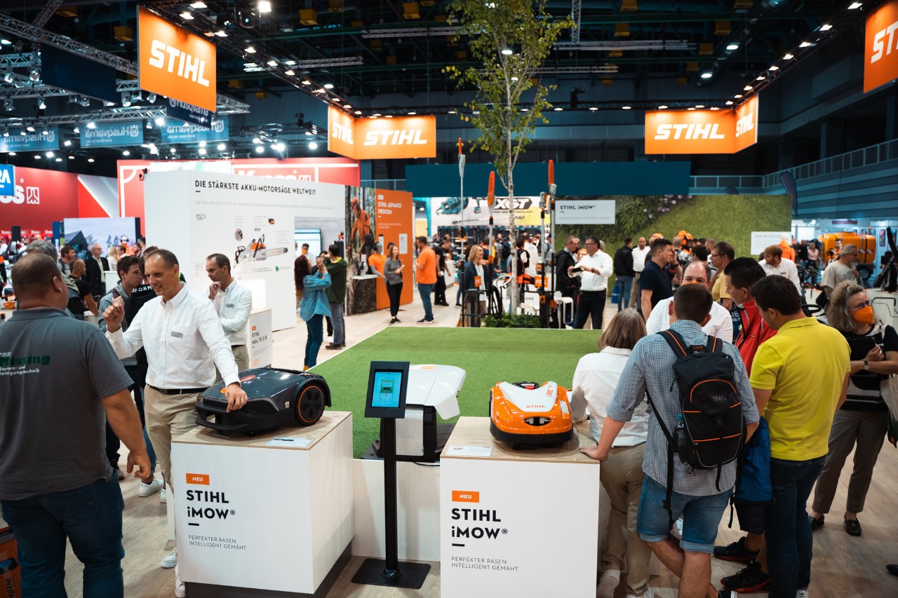 Stand de feira interior STIHL bem visitado com robôs corta-relvas iMOW®