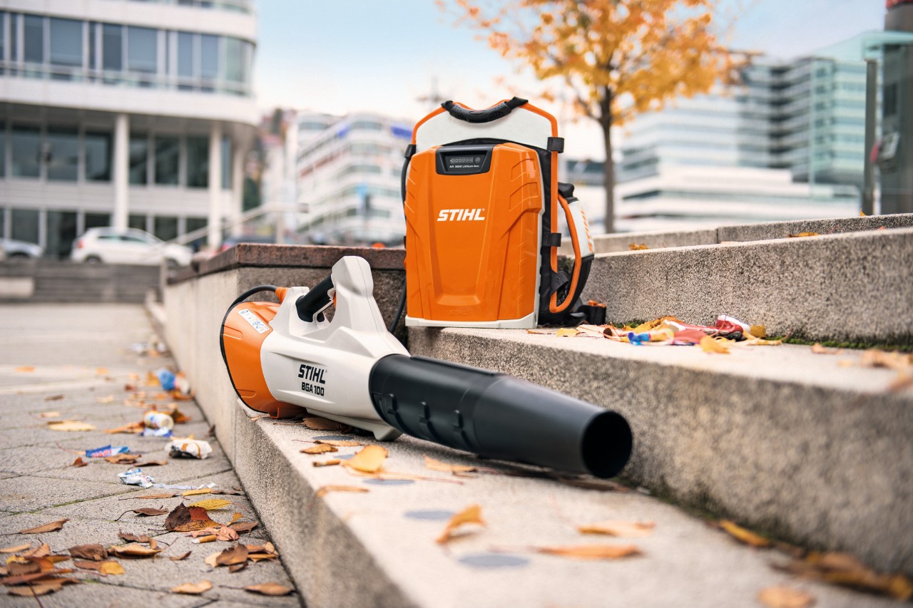 Numa escada de pedra, com algumas folhas caducas, estão o soprador a bateria STIHL BGA 100 e a bateria de mochila profissional STIHL AR 3000 L