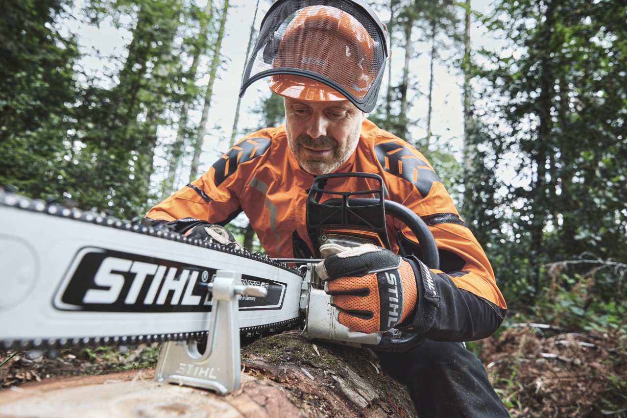 Um homem com equipamento de proteção a trabalhar com uma motosserra STIHL na floresta