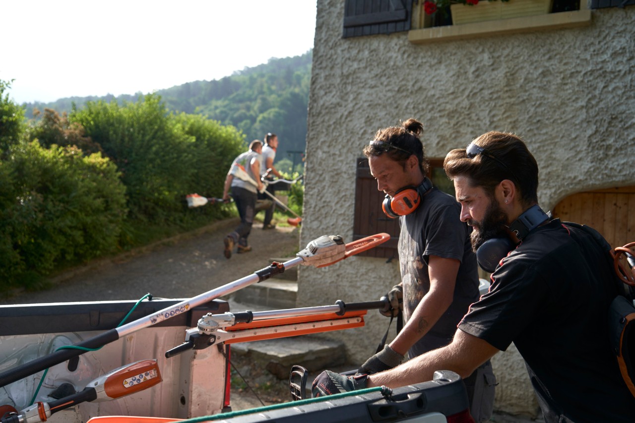 Julien Loquarelli, um paisagista, descarrega o equipamento STIHL do veículo juntamente com os seus colegas de trabalho.