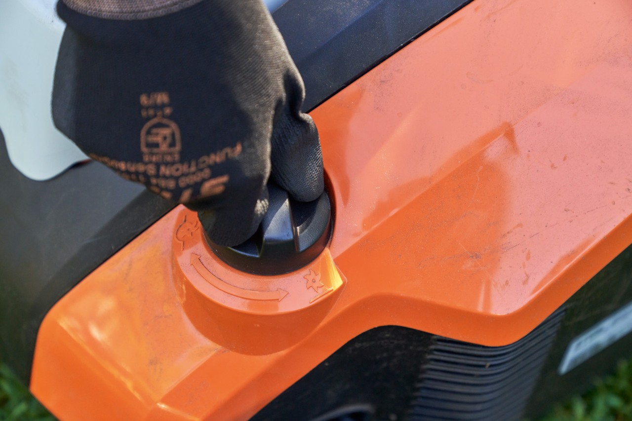 Imagem ampliada: Uma mão com a luvas de trabalho roda na pega giratória do arejador de relva a bateria STIHL RLA 240.