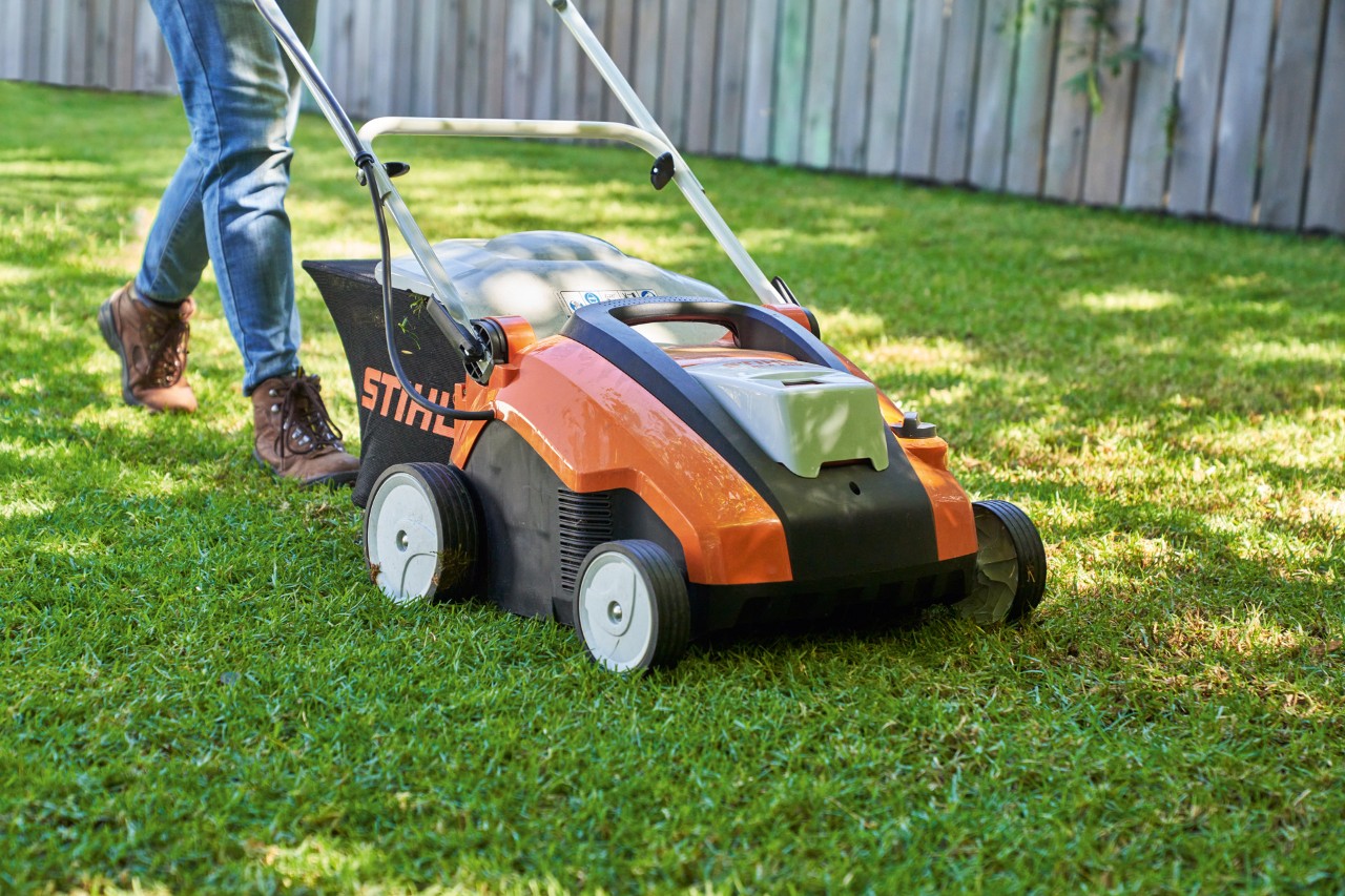 Arejador de relva a bateria STIHL RLA 240 durante a ventilação do relvado num espaco verde.