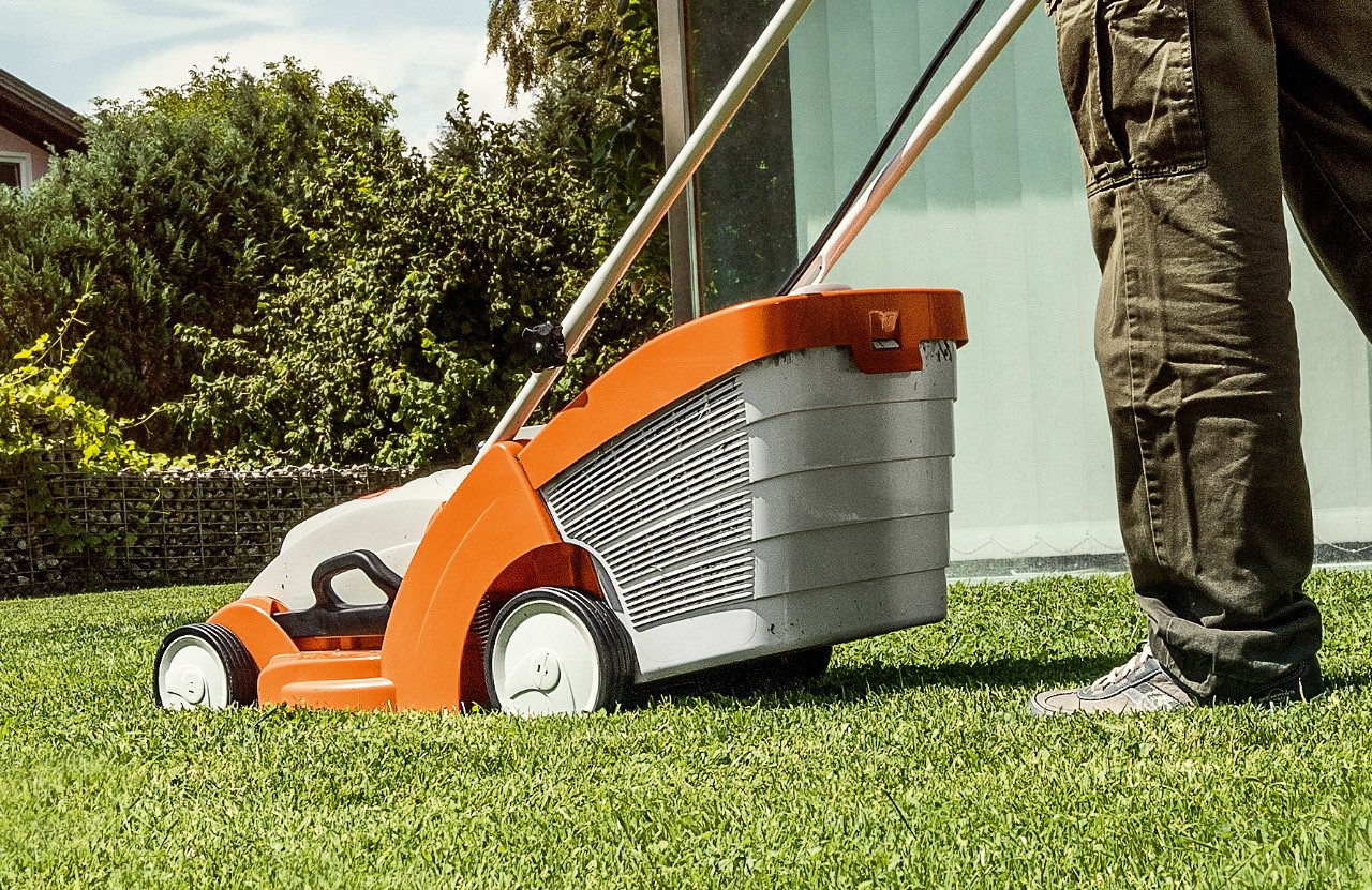 Uma máquina de cortar relva a bateria STIHL RMA 339 a ser usado num relvado verde