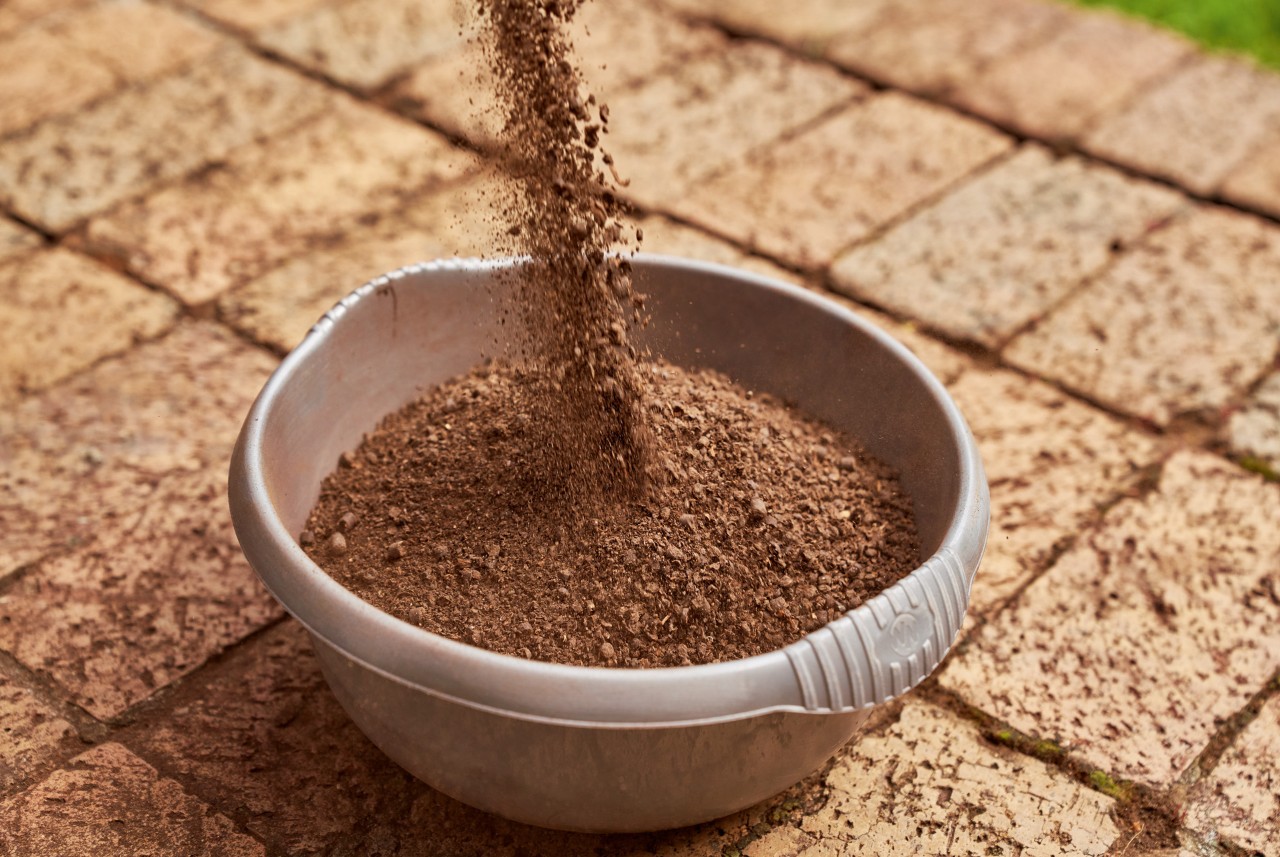 Fertilizante orgânico a ser deitado numa taça pronto para fertilizar a relva