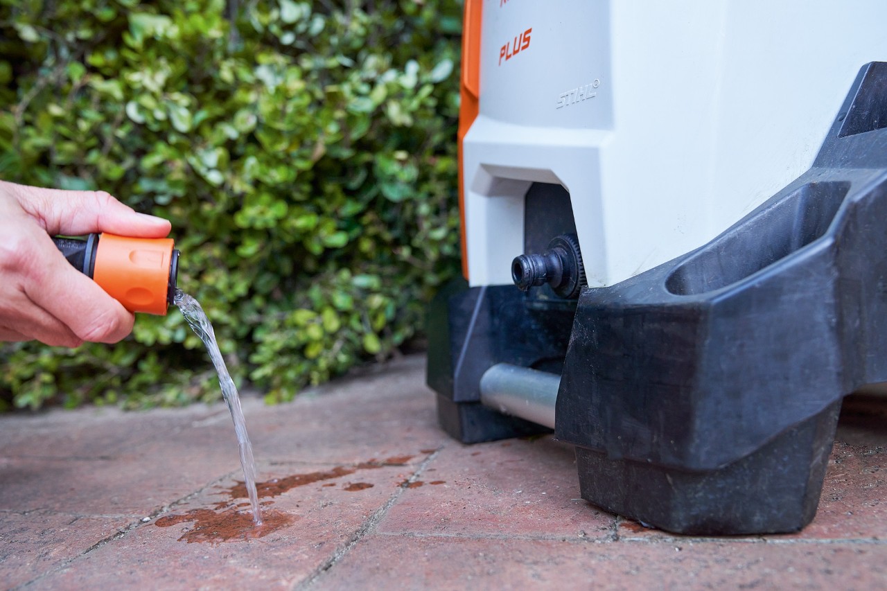 Uma pessoa limpa o filtro de entrada de água como parte da manutenção da lavadora de alta pressão STIHL RE 130 PLUS 