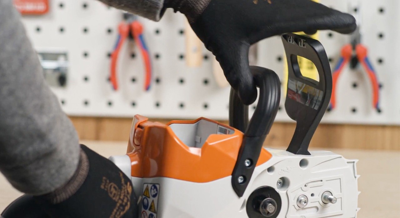 Substituir uma corrente de motosserra: o travão da corrente numa motosserra a bateria STIHL MSA 120 a ser libertado
