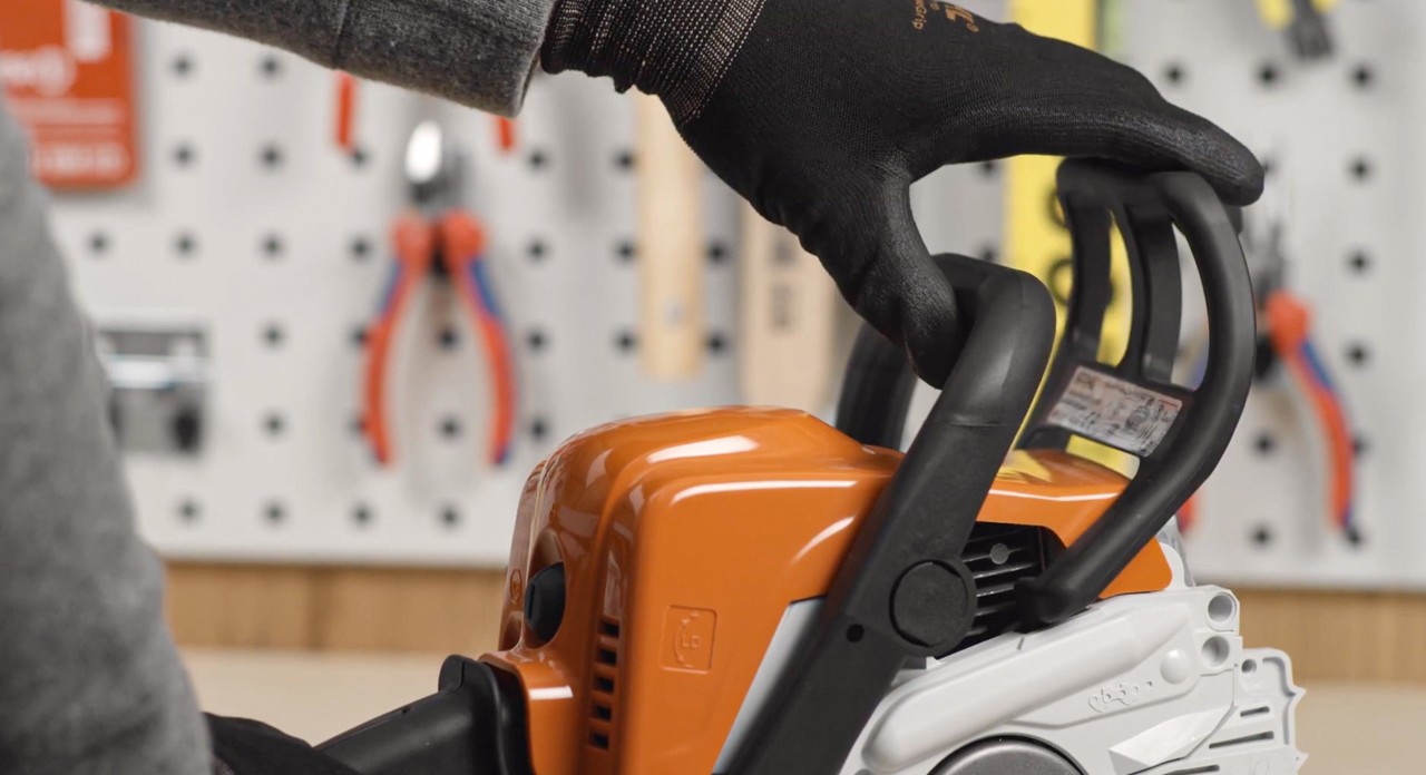 Substituir uma corrente de motosserra: o travão da corrente numa motosserra a bateria STIHL MSA 180 a ser libertado