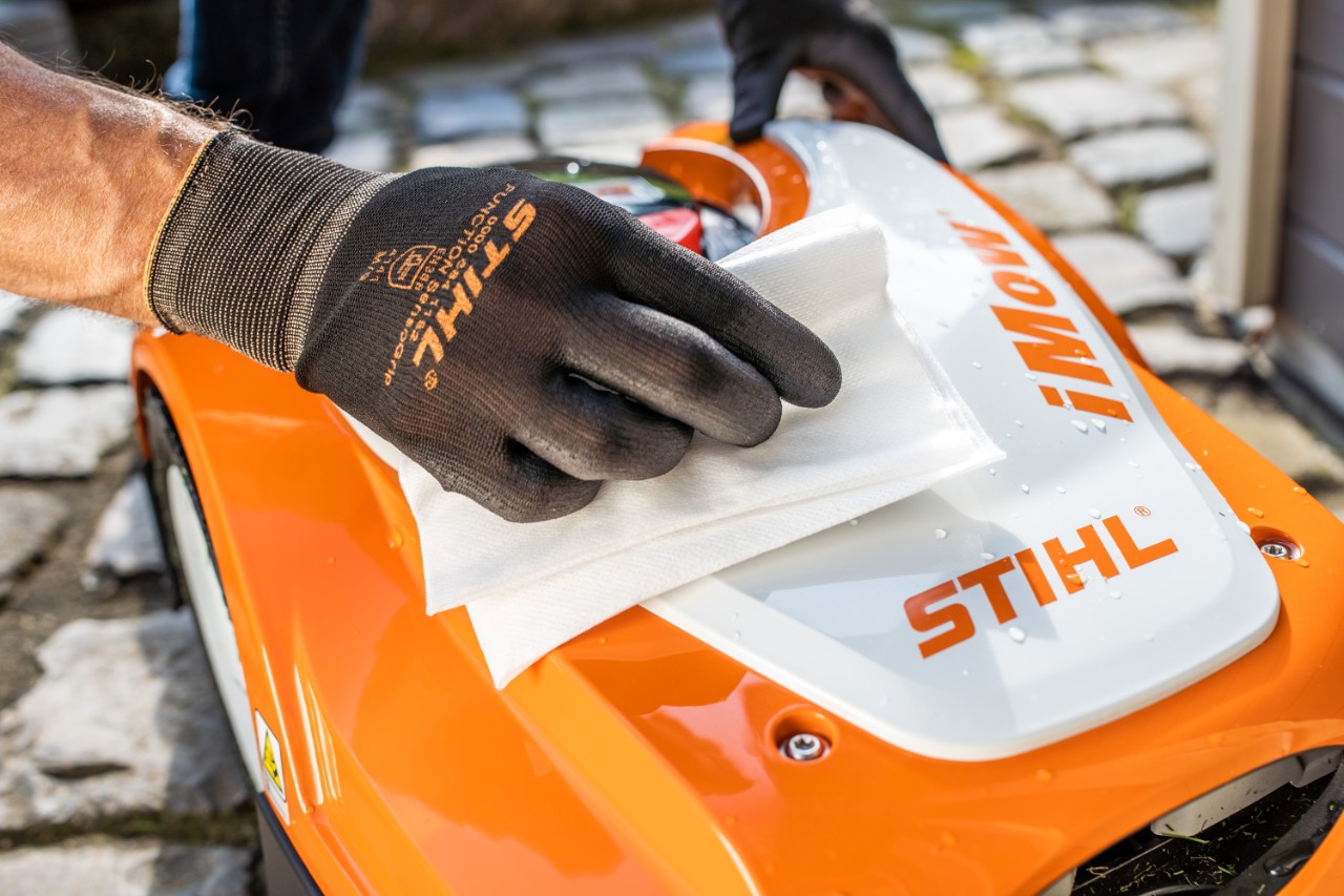  Um robot corta-relva STIHL iMOW® 422 a ser limpo com um pano e a ser preparado para o inverno