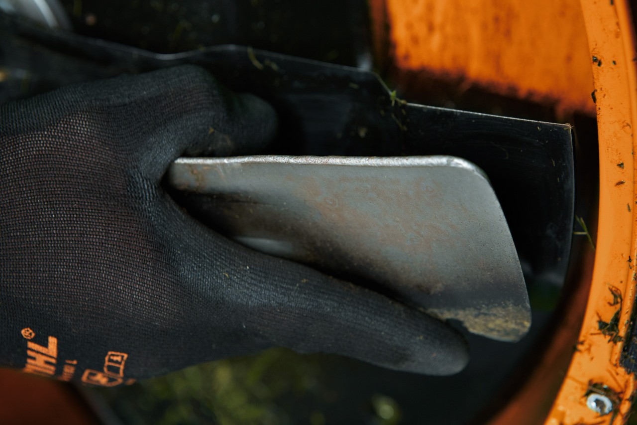 Imagem ampliada de uma espátula utilizada para limpar a parte inferior de um corta-relva STIHL