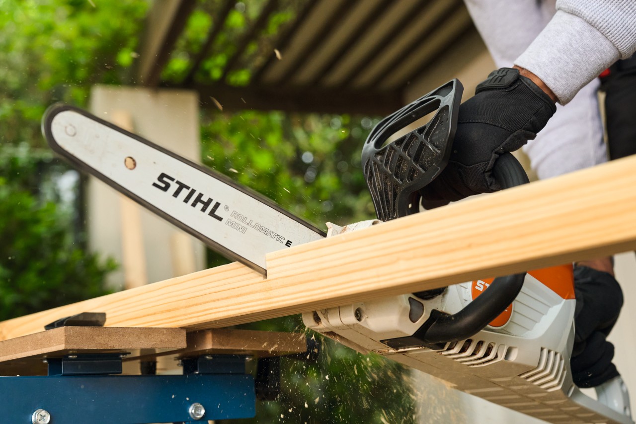 Um homem serra uma barra lateral para uma baliza de futebol com uma STIHL MSA 70