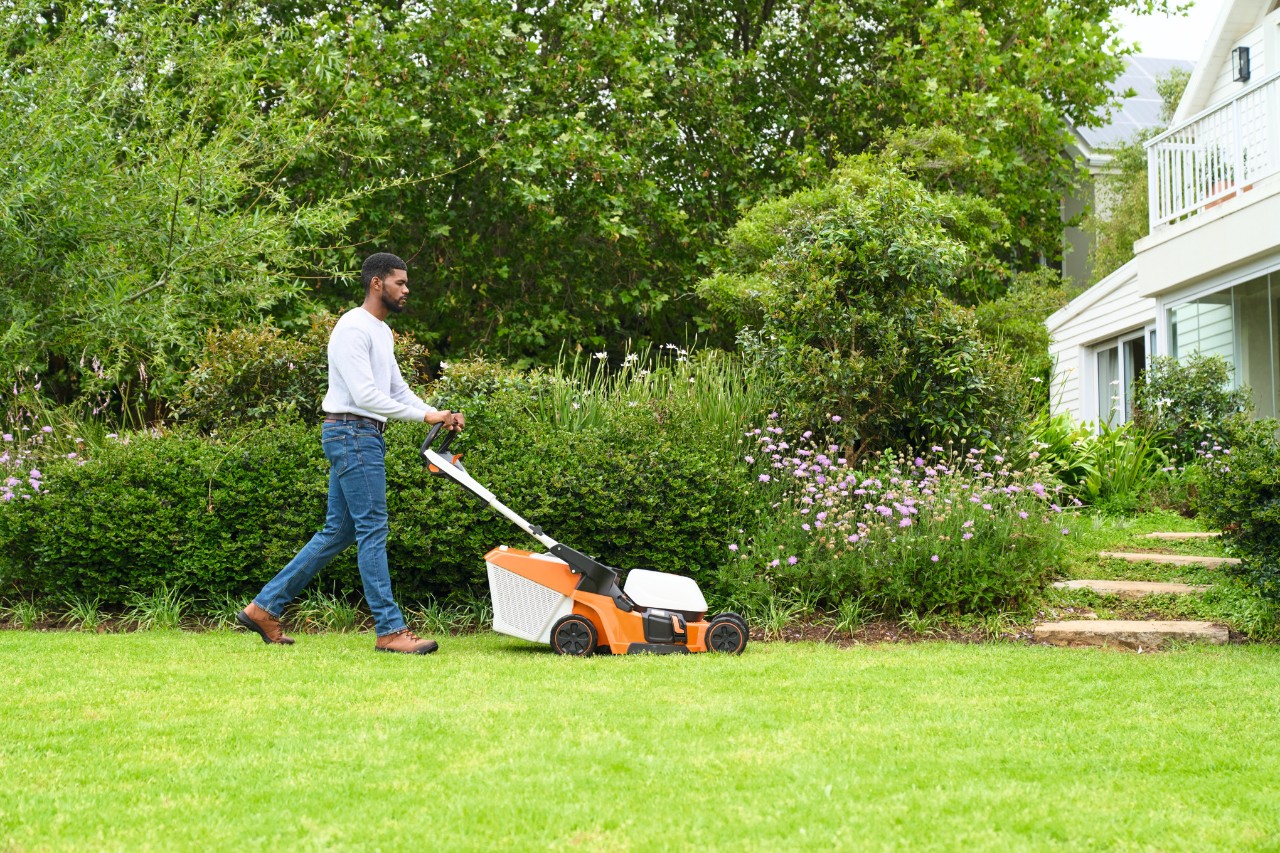 Um homem corta a relva com um corta-relvas STIHL RMA 448 V