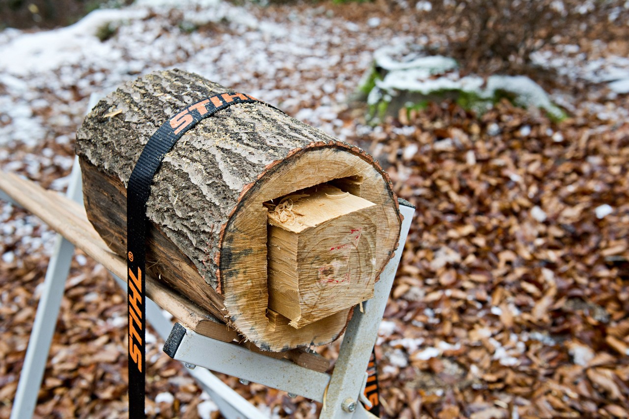 Lanterna de bricolage feita de um toro: um toro cortado fixado a um cavalete de serra com uma correia tensora STIHL