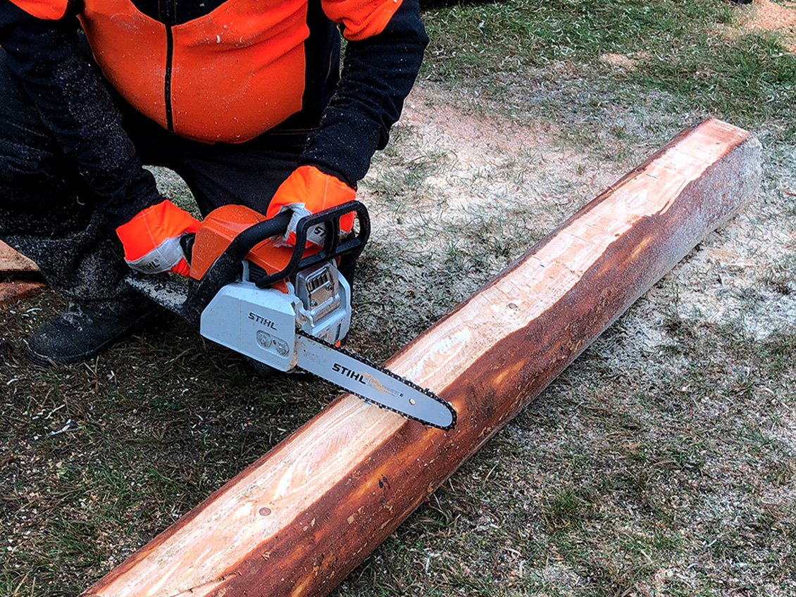 Mesa de bricolage para espaços verdes: pessoa com motosserra STIHL MS 170 encurta o comprimento do toro preparado