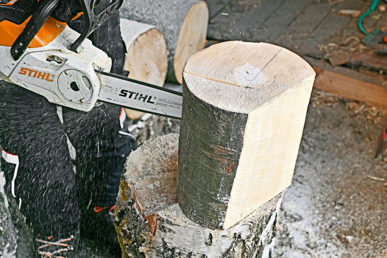 Um toro na vertical a ser cortado com uma motosserra STIHL MSA 140 C – como fazer porta revistas em madeira.