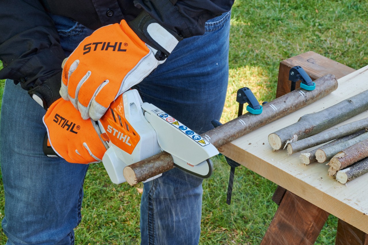 Coração de madeira a partir de um ramo: uma minipodadora de corrente a bateria STIHL GTA 26 a cortar um ramo 