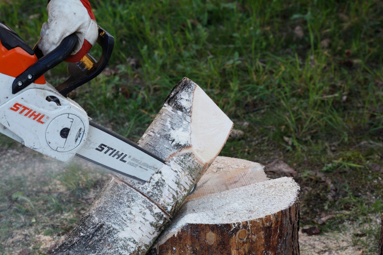 Castiçais de bricolage em madeira: uma motosserra STIHL MSA 140 C a esculpir a forma de uma chama num toro