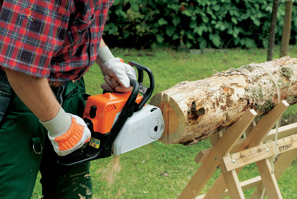 Uma peça plana do telhado é cortada a partir do centro do tronco com uma motosserra STIHL - construir casa para pássaros 