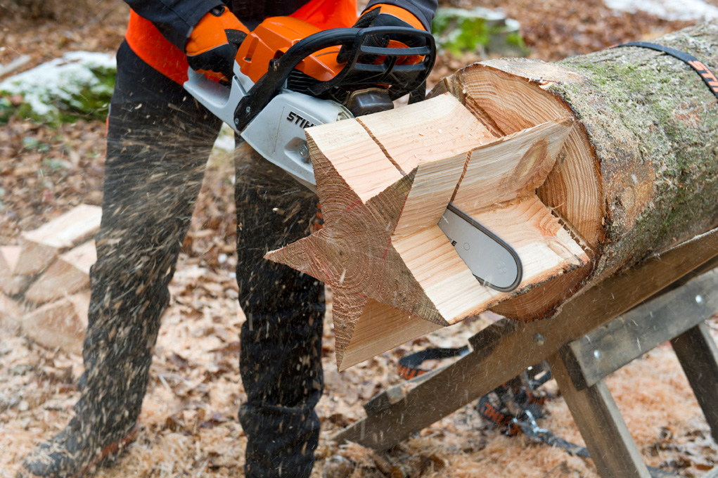 Fazer uma estrela de madeira: uma pessoa a cortar uma estrela a partir de um toro, utilizando a motosserra STIHL MS 261 C-M