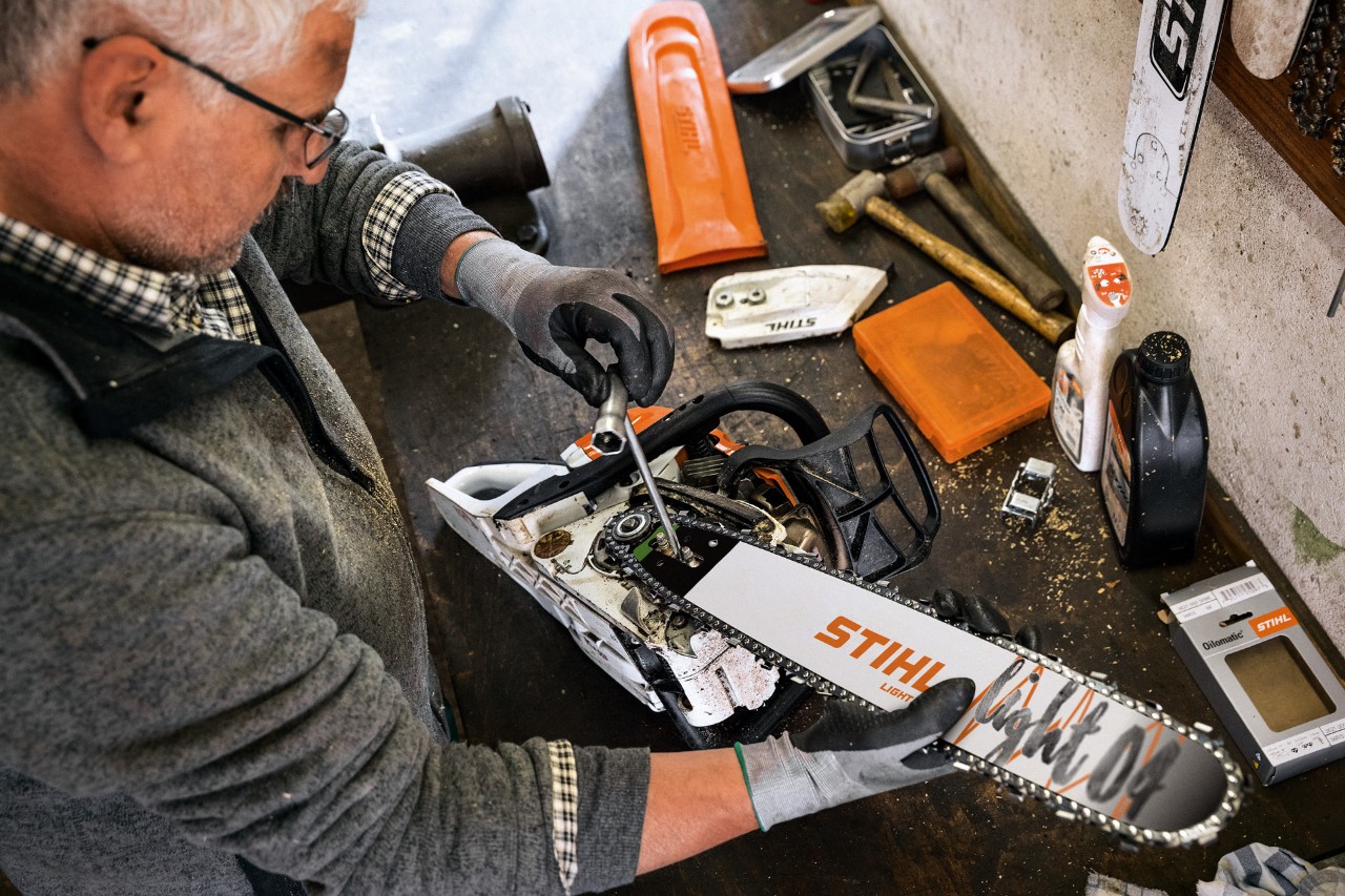Um concessionário STIHL efetua a manutenção de uma motosserra com uma guia STIHL Light 04 e uma corrente de serra Oilomatic