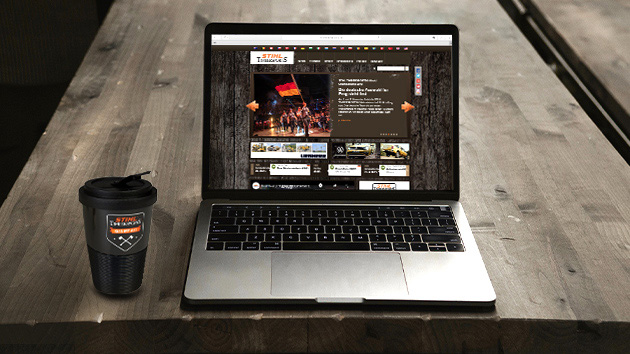 Portátil com o site da Timbersport aberto e uma caneca de café Timbersport