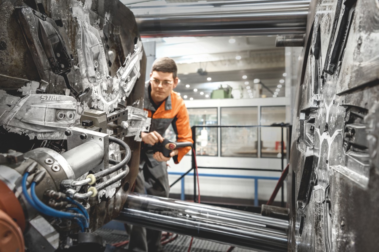 Uma pessoa opera a máquina para o processo de fundição na fábrica da STIHL, em Prüm
