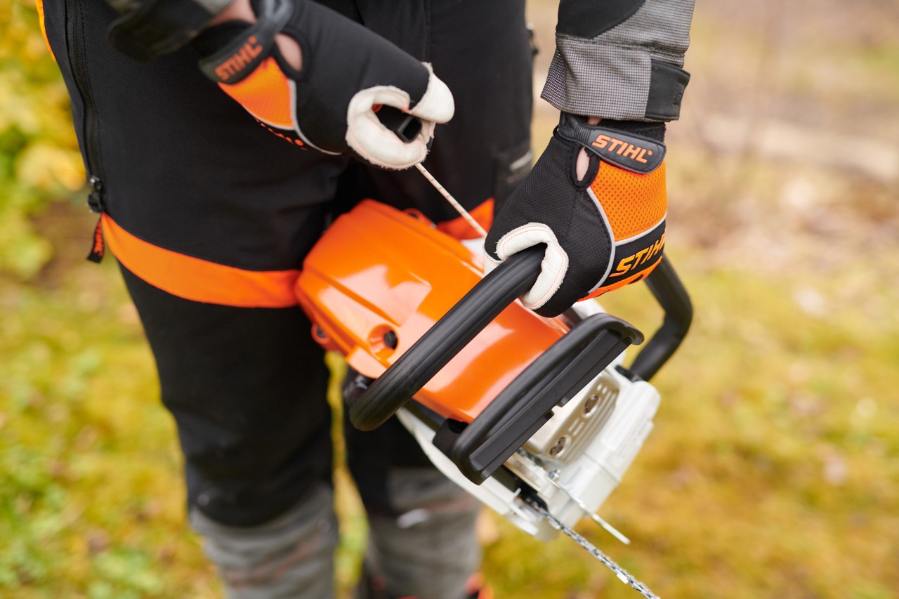 Arranque de motosserra a gasolina STIHL MS 261 C-M, com válvula de descompressão, por pessoa com vestuário de proteção