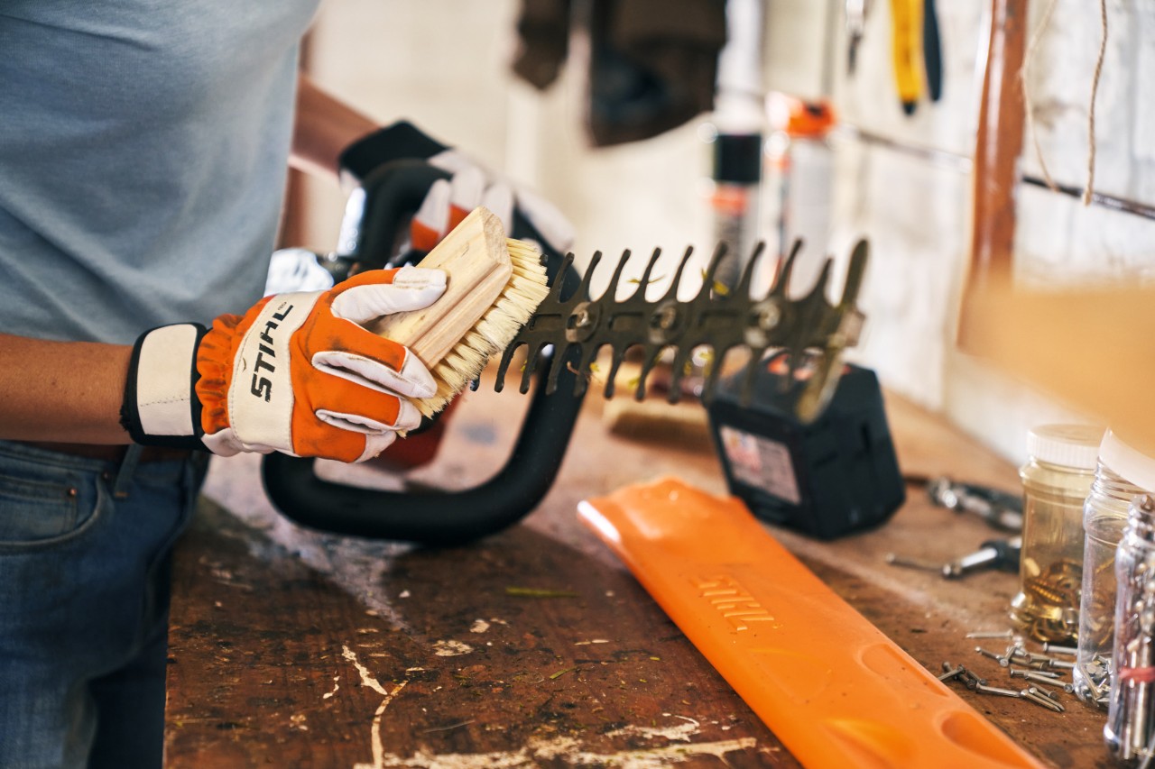 a tesoura podadora de sebes a bateria STIHL HSA 56 é limpa com uma escova