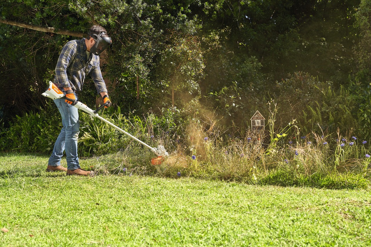 Um homem a cortar um prado de flores silvestres com a STIHL FSA 57