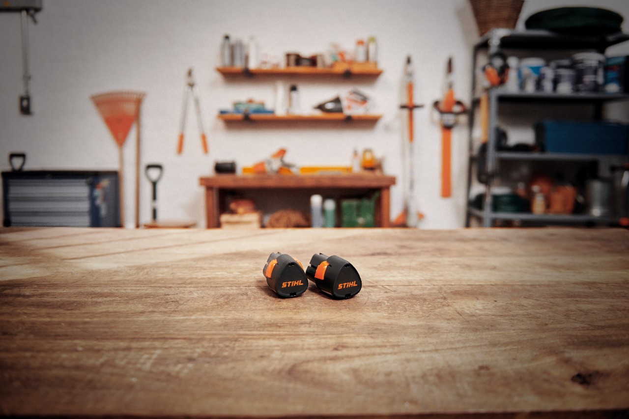 Oficina com uma bateria STIHL AK 30 S numa mesa de madeira 